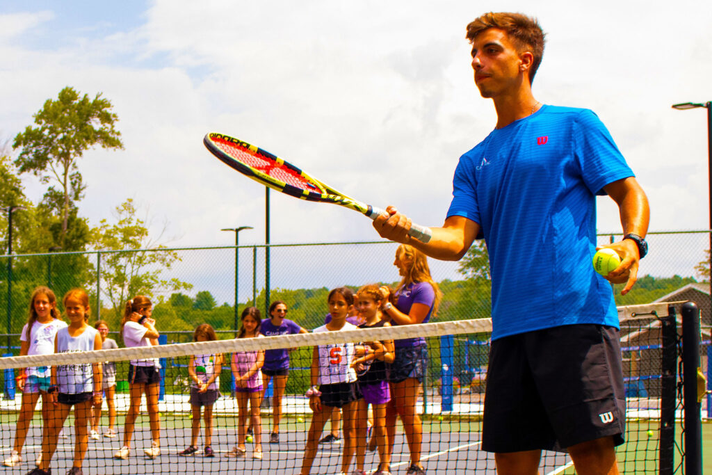Coaching tennis at camp means spending your summer outdoors helping campers perfect their serves and backhands.